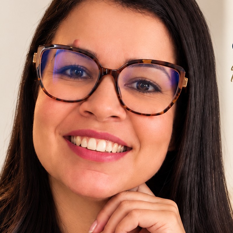 Vivi Freri sorrindo, de óculos, olhando para a câmera