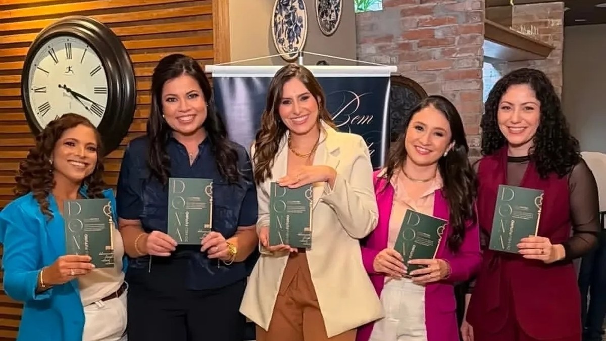 Cinco mulheres em pé segurando o livro Dona do Meu Futuro
